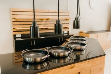 Moderne Buffetstation mit Edelstahlpfannen im Familienhotel Friedrichshof.