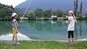 Kinder beim Angeln an einem Teich im Familienhotel Lärchenhof in Tirol