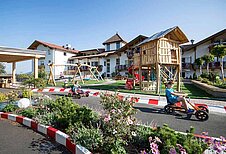 Kinder spielen auf dem Außenspielplatz im Family Home Alpenhof in Südtirol.