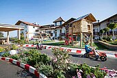 Kinder spielen auf dem Außenspielplatz im Family Home Alpenhof in Südtirol.