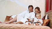 Eltern genießen Ihr Wellness mit Ihrem Kind zusammen und entspannen im Wellnessbereich im Familienhotel Sonnenpark im Hochsauerland.