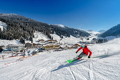 Ein Hotelgast des Familienhotels Zauchenseeof erfreut sich über die Skipiste und fährt diese im Schneegetümmel hinunter.