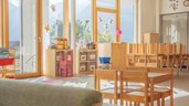 Sonnendurchflutetes Spielzimmer im Familienhotel Kindl mit Blick ins Freie, Bällebad und verschiedene Spielbereichen für Kinder