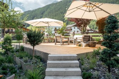 Gemütlicher Terrassenbereich mit Sonnenschirmen und Loungemöbeln im Familienhotel Kindl.