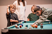 Familie spielt Billard im Familienhotel Alpenhof Dolomit Family