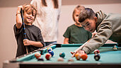 Familie spielt Billard im Familienhotel Alpenhof Dolomit Family