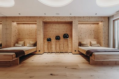 Moderner Ruheraum mit gemütlichen Liegen aus Holz im Familienhotel Habachklause.