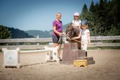 Kinder beim Ponyreiten mit Betreuung auf dem Reitplatz des Familienhotels Krone im Allgäu.