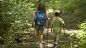 Zwei Kindern wandern im Wald im Allgäu.
