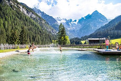 Sommeransicht auf den Badesee im Familienhotel Bella Vista in Südtirol.