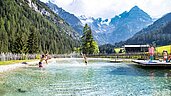 Sommeransicht auf den Badesee im Familienhotel Bella Vista in Südtirol.