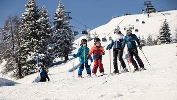 Eine Familie beim Winterurlaub mit Kinder bei Familotel 