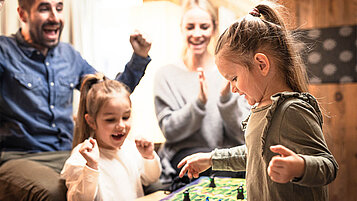 Familie spielt ein Spiel in der Lobby und genießt den Kurzurlaub.