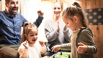 Familie spielt ein Spiel in der Lobby und genießt den Kurzurlaub.