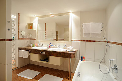 Modernes Badezimmer mit einer Badewanne und zwei Waschbecken im Familienhotel Das Hopfgarten in Tirol.