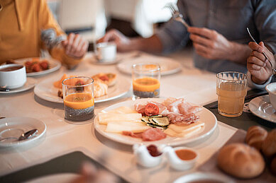 Gedeckter Frühstückstisch im Frühstücksraum des Familienhotels Family Home Alpenhof.