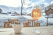Ein Glas Aperol und Snacks stehen auf der Terrasse des Familienhotels Gorfion in Liechtenstein