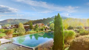 Luftaufnahme von Landschaft und Naturpool des Familienhotels Landgut Furtherwirt in Tirol.