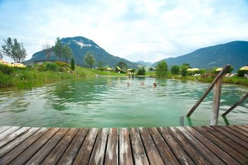 Der idyllische Badeteich mitten in der Berglandschaft lädt im Landgut Furtherwirt zum entspannten Schwimmen und Genießen ein