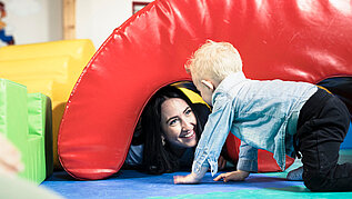 Kinderbetreuerin spielt gemeinsam mit Kleinkind im Happy-Club