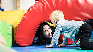 Kinderbetreuerin spielt gemeinsam mit Kleinkind im Happy-Club