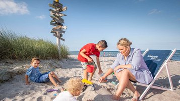 Familie spielt im Sand am Strand an der Ostsee.
