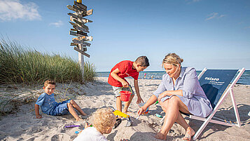Familie spielt im Sand am Strand an der Ostsee.