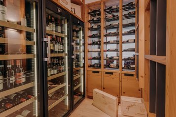 Gut sortierter Weinschrank mit edlen Flaschen im Familienhotel Habachklause.