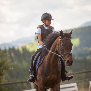 Ein Mädchen reitet auf einem Pferd beim Familienhotel Der Ponyhof in der Steiermark