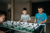 Am Kickertisch liefern sich die Jungs im Familienhotel Friedrichshof ein spannendes Match.