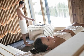 Eltern entspannen in der Sauna im Adults Only Wellnessbereich im Familienhotel Allgäuer Berghof.