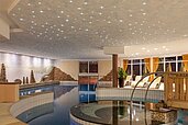 Schwimmbad mit Sternenhimmel und einem Sprudelbecken im Familienhotel Alphotel Tyrol Wellness & Family Resort in Südtirol.