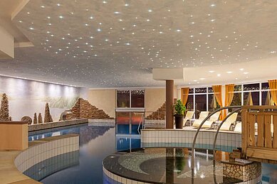 Schwimmbad mit Sternenhimmel und einem Sprudelbecken im Familienhotel Alphotel Tyrol Wellness & Family Resort in Südtirol.