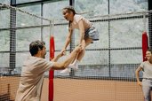 Ein Vater springt mit seiner Tochter gemeinsam auf einem Trampolin in der Erlebnishalle des Hotel Sonngastein im Salzburger Land.