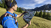 Ohne Navigation geht heute nichts. Ein Mann benutzt eine Karte um sich beim Wandern in Tirol zurecht zu finden.