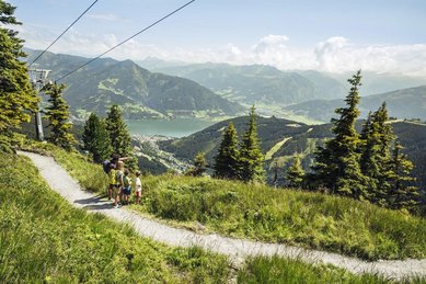 Familie beim Wandern im Sommer auf die Schmittenhöhe in Zell am See mit Panoramablick auf den See