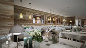 Der Speisesaal Valuna im Familienhotel Gorfion in Liechtenstein mit hell gedeckten Tischen im neuen Restaurant.
