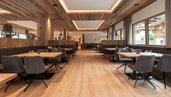 Modernes Restaurant mit Holzdesign und gemütlichen Sitzbereichen im Familienhotel Oberkarteis.