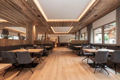 Modernes Restaurant mit Holzdesign und gemütlichen Sitzbereichen im Familienhotel Oberkarteis.