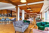 Lounge mit Ohrensesseln und einer Bar im Familienhotel Familien Resort Petschnighof in Kärnten.