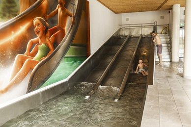 Drei Kinder rutschen die Triple Slide Rutsche des Almfamilyhotels Scherer hinunter.