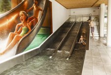 Drei Kinder rutschen die Triple Slide Rutsche des Almfamilyhotels Scherer hinunter.