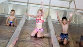 Drei Kinder rutschen die Triple Slide Rutsche des Almfamilyhotels Scherer hinunter.