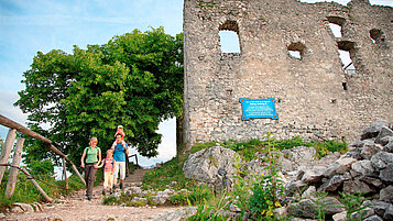 Familie wandert an der Burg Falkenstein im Allgäu vorbei.
