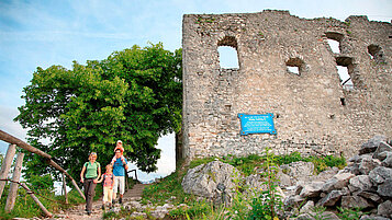 Familie wandert an der Burg Falkenstein im Allgäu vorbei.