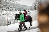 Ein geführter Ausritt mit der Familie im Winter im Familienhotel Der Ponyhof Steiermark.