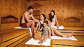 Vierköpfige Familie gemeinsam in der Familien-Sauna des Familienhotels Alpenhotel Kindl in Tirol.