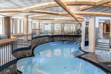 Lichtdurchflutetes Hallenbad des Familienhotels Kindl mit modernem Design und gemütlichen Ruhebereichen