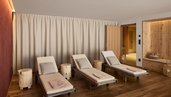 Heller Ruheraum im Familienhotel Bella Vista in Südtirol mit Liegen, Holzboden und warmem Licht.