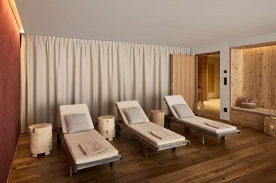 Heller Ruheraum im Familienhotel Bella Vista in Südtirol mit Liegen, Holzboden und warmem Licht.